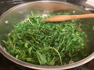 Watercress cooking in a skillet