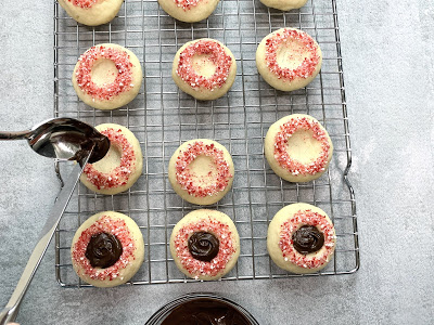 Thumbprint cookies being filled with chocolate peppermint spread