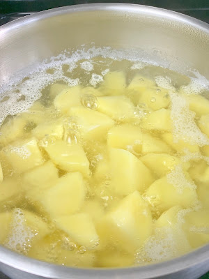Potatoes boiling on a pot of water