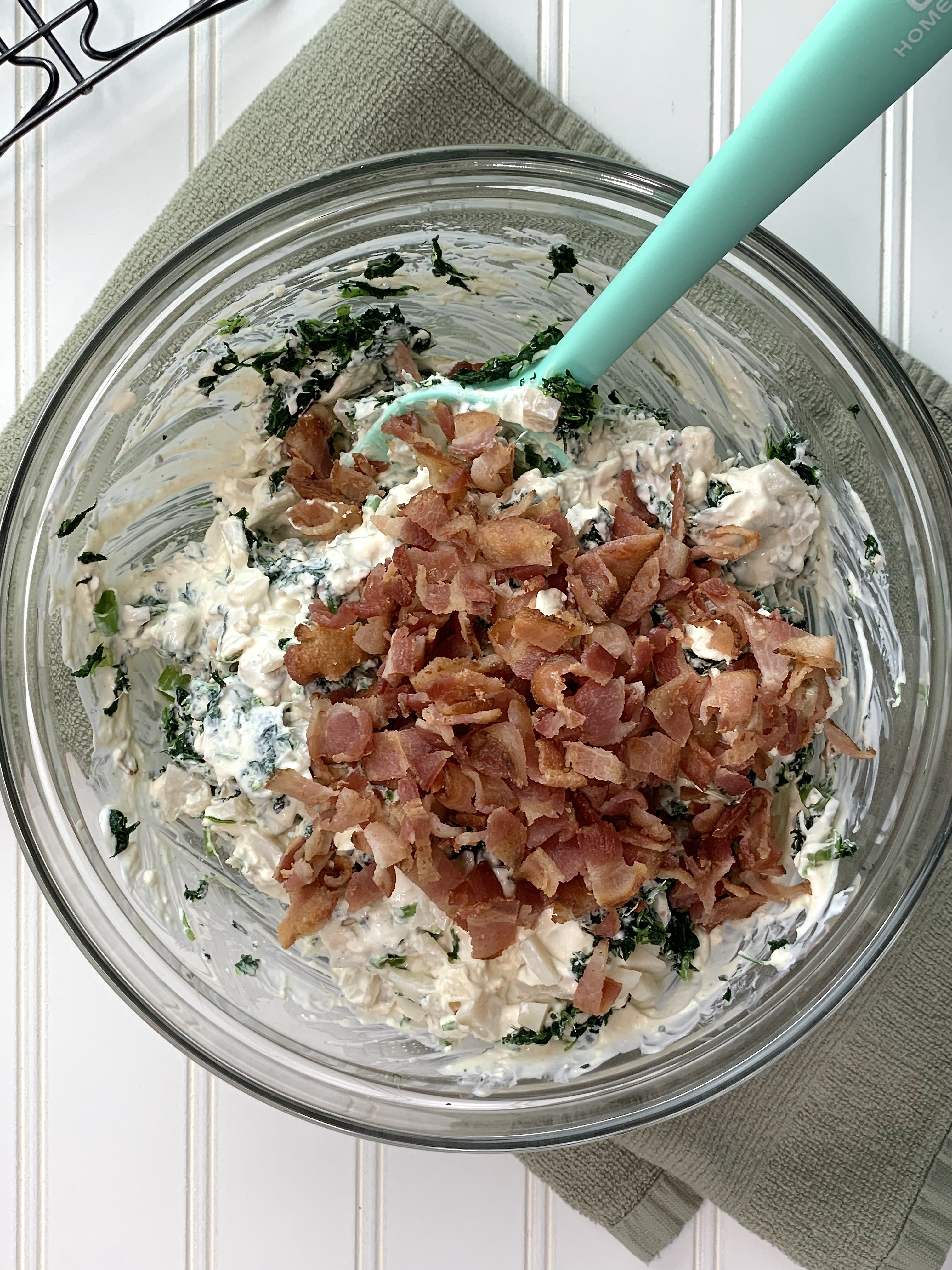 Spinach and bacon dip mixing in bowl